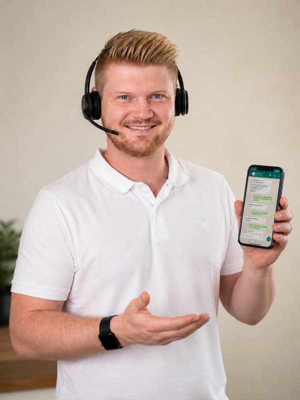 Christopher Böhnisch mit Headset und WhatsApp am Smartphone